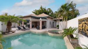 a swimming pool in front of a house at Orchid Paradise Homes OPV 210 in Hua Hin