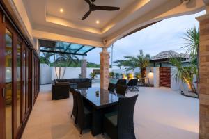 an outdoor patio with a dining table and chairs at Orchid Paradise Homes OPV 210 in Hua Hin