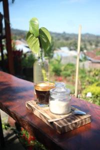 una taza de té y un frasco de cristal sobre una mesa de madera en Balelangga Bed & Breakfast en Sapit