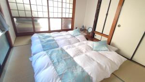 大川的住宿－Okawaya - Vacation STAY 49372v，一间卧室配有三张床,铺有蓝色和白色的床单