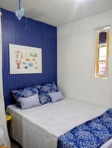 Schlafzimmer mit einem Bett mit blauer und weißer Bettwäsche in der Unterkunft Chalés Caiçara Serrambi in Porto De Galinhas