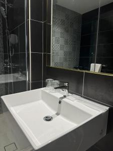 La salle de bains est pourvue d'un lavabo blanc et d'un miroir. dans l'établissement Le'genda Hotel, à Kajang