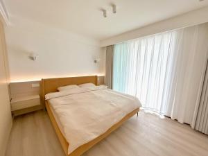ZHome-Modern 3 bedrooms apartment - near NanJing Road في شانغهاي: سرير في غرفة مع نافذة كبيرة