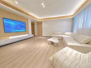 un grand salon avec une grande télévision à écran plat dans l'établissement ZHome-Modern 3 bedrooms apartment - near NanJing Road, à Shanghai