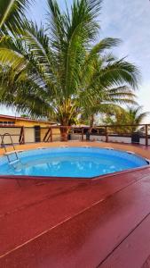 a swimming pool with a palm tree in the background at AQIL BEACH INN in Marang +11 photos