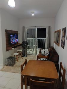 een woonkamer met een bank en een tafel bij Apartamento encantador 22 in Ubatuba
