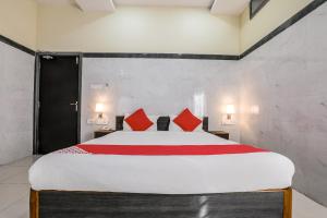 a bedroom with a large bed with red pillows at Hotel Src Grand in Vijayawāda