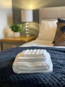 tre asciugamani bianchi seduti sopra un letto di 3- Lovely 1 Bed Apartment extra sofa bed-West Midlands 