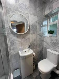 een badkamer met een wit toilet en een spiegel bij 3- Lovely 1 Bed Apartment extra sofa bed-West Midlands 