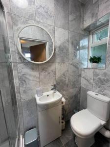 a bathroom with a white toilet and a mirror at 3- Lovely 1 Bed Apartment extra sofa bed-West Midlands 