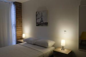 een slaapkamer met een bed en een foto van de eiffeltoren bij Chapinero Central in Bogota