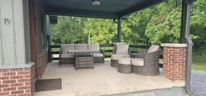 a screened porch with a table and chairs on it at Cozy Compass House in Tellico Plains