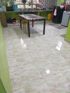 a tile floor with a table in a room at ABAH HOMESTAY, MANIR, KUALA TERENGGANU (HOMESTAY A) in Kuala Terengganu