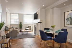 un soggiorno con tavolo e sedie blu di Deluxe Mayfair Luxury Apartment a Londra