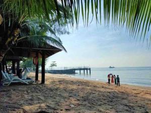 a group of people standing on a beach with a pier at Full Seaview 3BR 3BD Duplex Apartment 房间全面向海景-3房 3卫 复式公寓 in Port Dickson