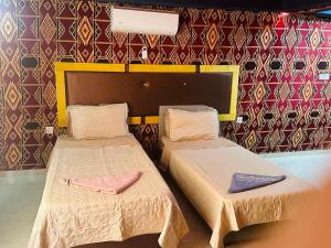 dwa łóżka w pokoju ze ścianą w obiekcie Shakria Bedouin Life Camp w mieście Wadi Rum