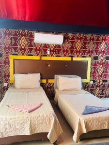 two beds sitting next to each other in a room at Shakria Bedouin Life Camp in Wadi Rum