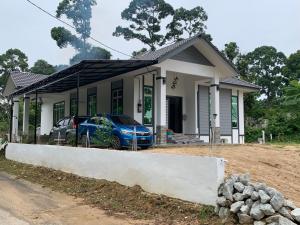 uma pequena casa com um carro estacionado em frente em Dhuha & Dharyl's Staycation em Kota Bharu