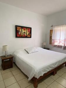 een slaapkamer met een groot wit bed en 2 tafels bij Mesón Don Quijote in Ajijic