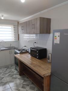 a kitchen with a wooden counter and a refrigerator at Entre Volcanes in Licán Ray