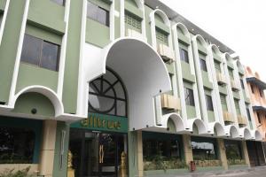 an office building with a white and green facade at Alltrue Hotel Bintan - Tanjungpinang in Tanjung Pinang
