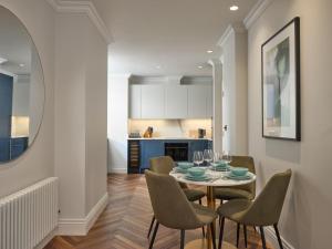 eine Küche und ein Esszimmer mit einem Tisch und Stühlen in der Unterkunft Deluxe Mayfair Luxury Apartment in London