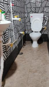 a bathroom with a toilet and a black and white wall at Manavi Home Stay in Mathura