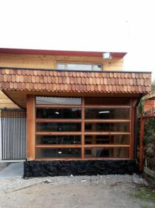 a garage with wooden doors and a brown roof at Entre Volcanes in Licán Ray