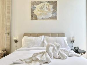 a white bed with a swan sitting on top of it at The Blue Lion Villa koh Samui - Sea view in Chaweng Noi Beach +28 photos