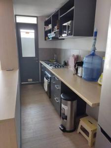 una pequeña cocina con encimera y fregadero en Apartamento condominio Arica en Arica