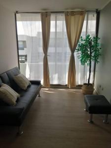 a living room with a couch and a large window at Apartamento condominio Arica in Arica
