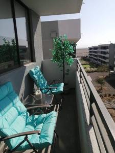 a balcony with chairs and a table on a building at Apartamento condominio Arica in Arica