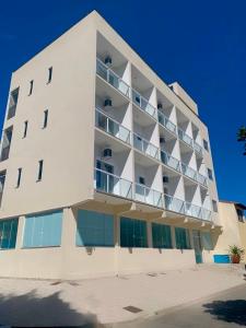 a large white building with balconies on the side of it at Pousada Himura in Angra dos Reis