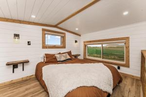 a bedroom with a large bed and a window at Modern Tiny Cabin, with Hot tub in Choteau MT in Choteau