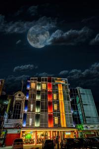 a building with the moon in the sky behind it at Parkside Alhambra Hotel Banda Aceh in Banda Aceh
