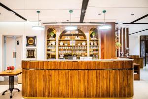 a large wooden bar in a restaurant with lights at Parkside Alhambra Hotel Banda Aceh in Banda Aceh