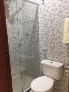 uma casa de banho com um WC e uma cabina de duche em vidro. em Pousada Himura em Angra dos Reis