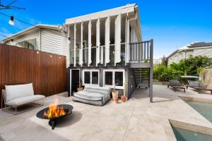 un patio con una hoguera frente a una casa en The Clay House, en Brisbane