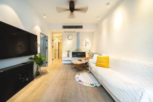 a living room with a white couch and a flat screen tv at Shanghai Celebrity Courtyard B&B in Shanghai