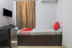 uma pequena cama num quarto com televisão em OYO Hotel Shiva em Guwahati