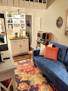 a living room with a blue couch and a kitchen at Cute tiny-apartment loft near NC State in Raleigh