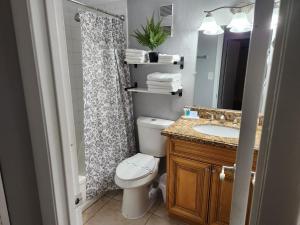 a bathroom with a toilet and a sink and a shower at Beautiful 2-Bedroom Condo Near Universal and other Orlando Attractions, King Bed & Wi-Fi in Orlando +28 photos