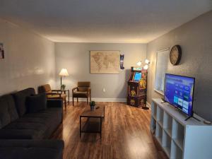 ein Wohnzimmer mit einem Sofa und einem Flachbild-TV in der Unterkunft Centauri Vacation Rentals Beautiful 2-bedroom condo, near all Orlando attractions, free parking & Wi-Fi, King bed in Orlando