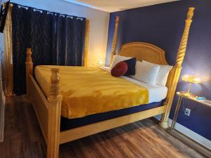Schlafzimmer mit einem Holzbett mit gelben Laken und Kissen in der Unterkunft Centauri Vacation Rentals Beautiful 2-bedroom condo, near all Orlando attractions, free parking & Wi-Fi, King bed in Orlando
