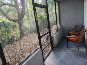 eine offene Tür zu einer Veranda mit einem Stuhl in der Unterkunft Centauri Vacation Rentals Beautiful 2-bedroom condo, near all Orlando attractions, free parking & Wi-Fi, King bed in Orlando