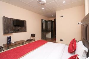 a bedroom with a bed and a tv on the wall at Hotel Abc Residency in Jawāharnagar