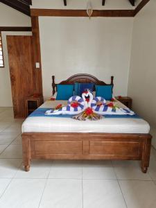 a bed with blue pillows and a wooden head board at Hideaway Island Resort in Port Vila