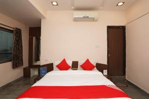 a bedroom with a large bed with red pillows at OYO Hotel Emerald in Raipur