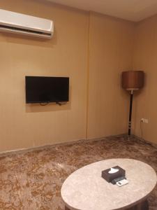 Habitación con mesa y TV de pantalla plana. en فندق دان البلاتيني, en Medina