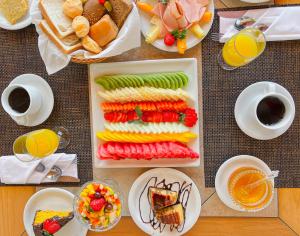 فندق بالاس برايا في فلوريانوبوليس: طاولة مع أطباق من الطعام وأكواب من القهوة
